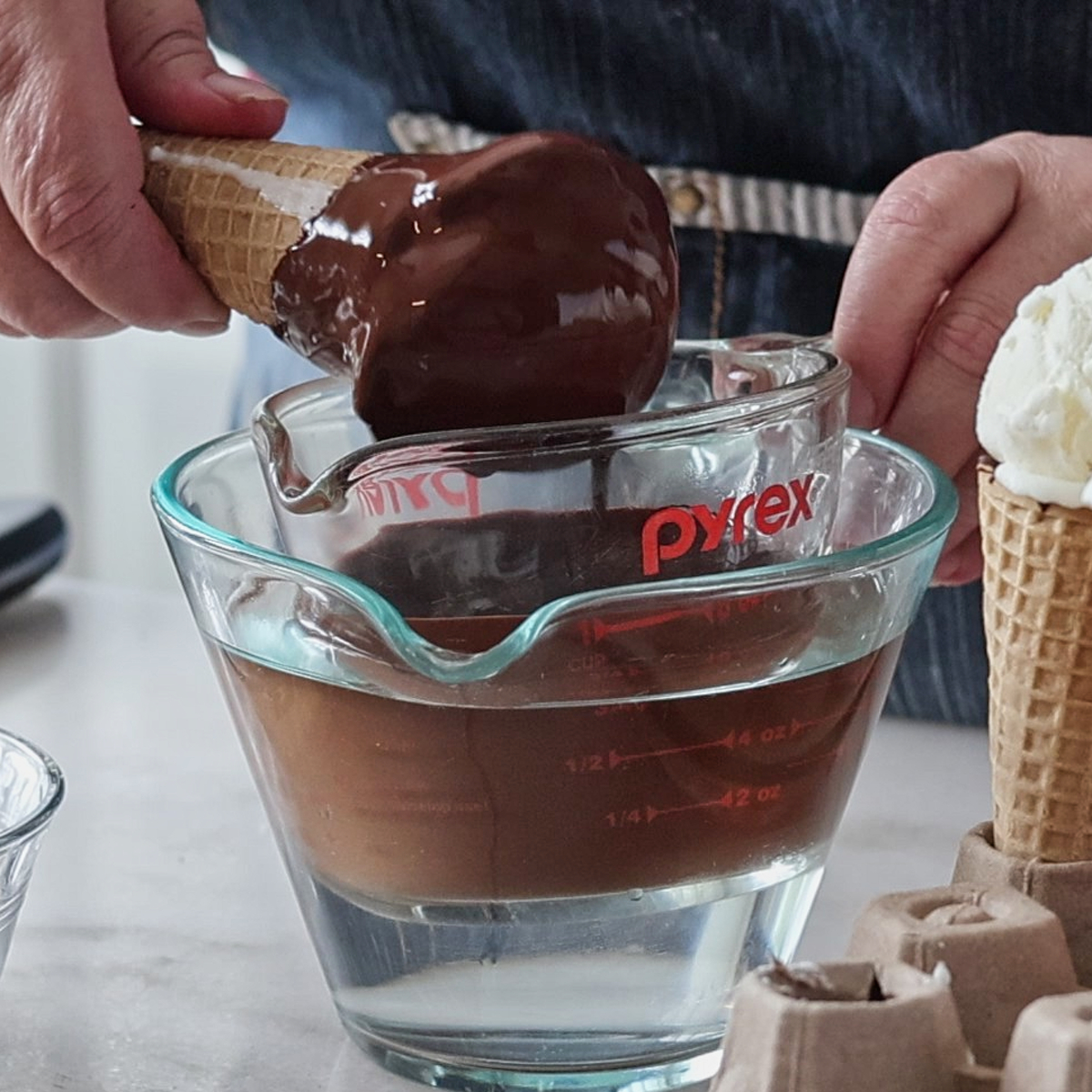 dipping ice cream cone in chocolate.