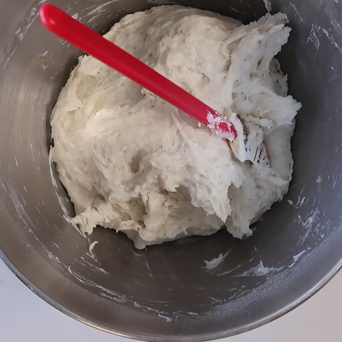 rough pizza dough in stainless steel mixing bowl.