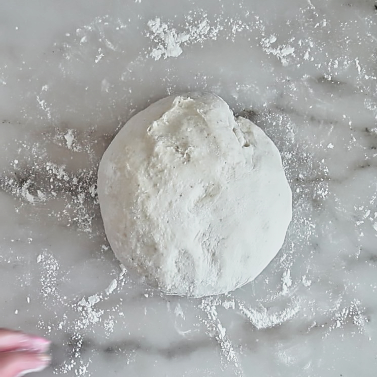 pizza dough on marble surface.