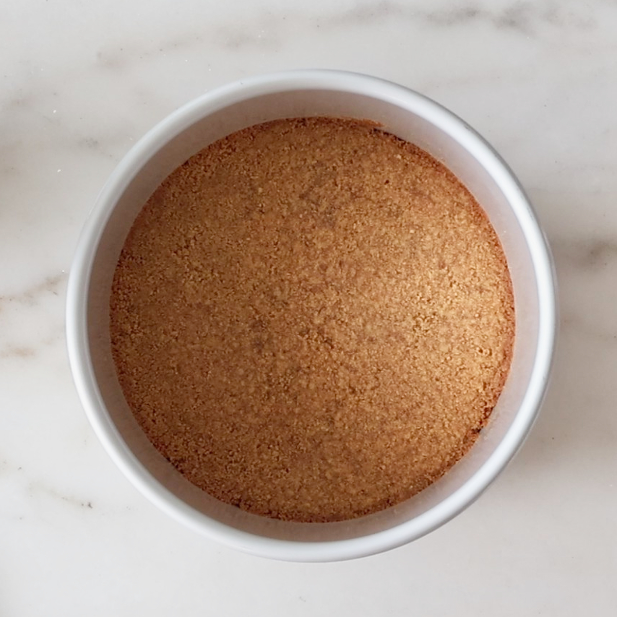 baked cheesecake crust in cake pan.