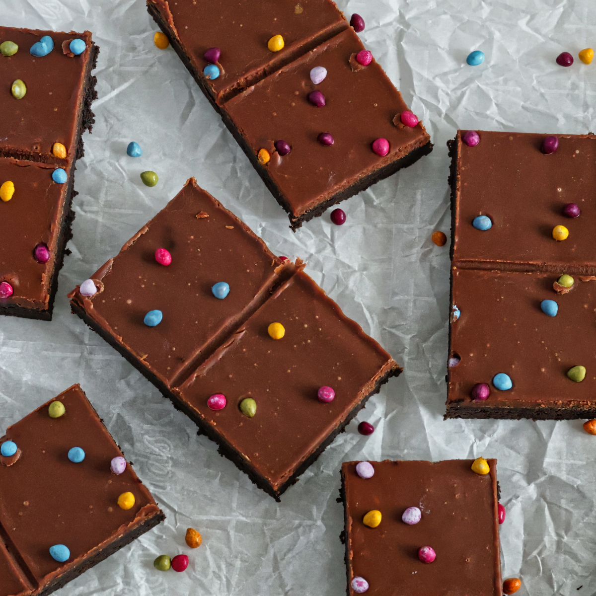 cosmic brownies scattered out on a piece of white crumpled parchment paper.