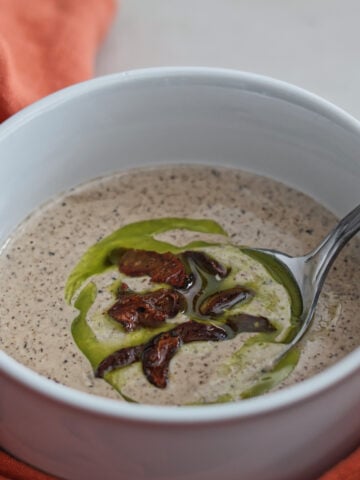 mushroom soup in bowl with orange towel around it.