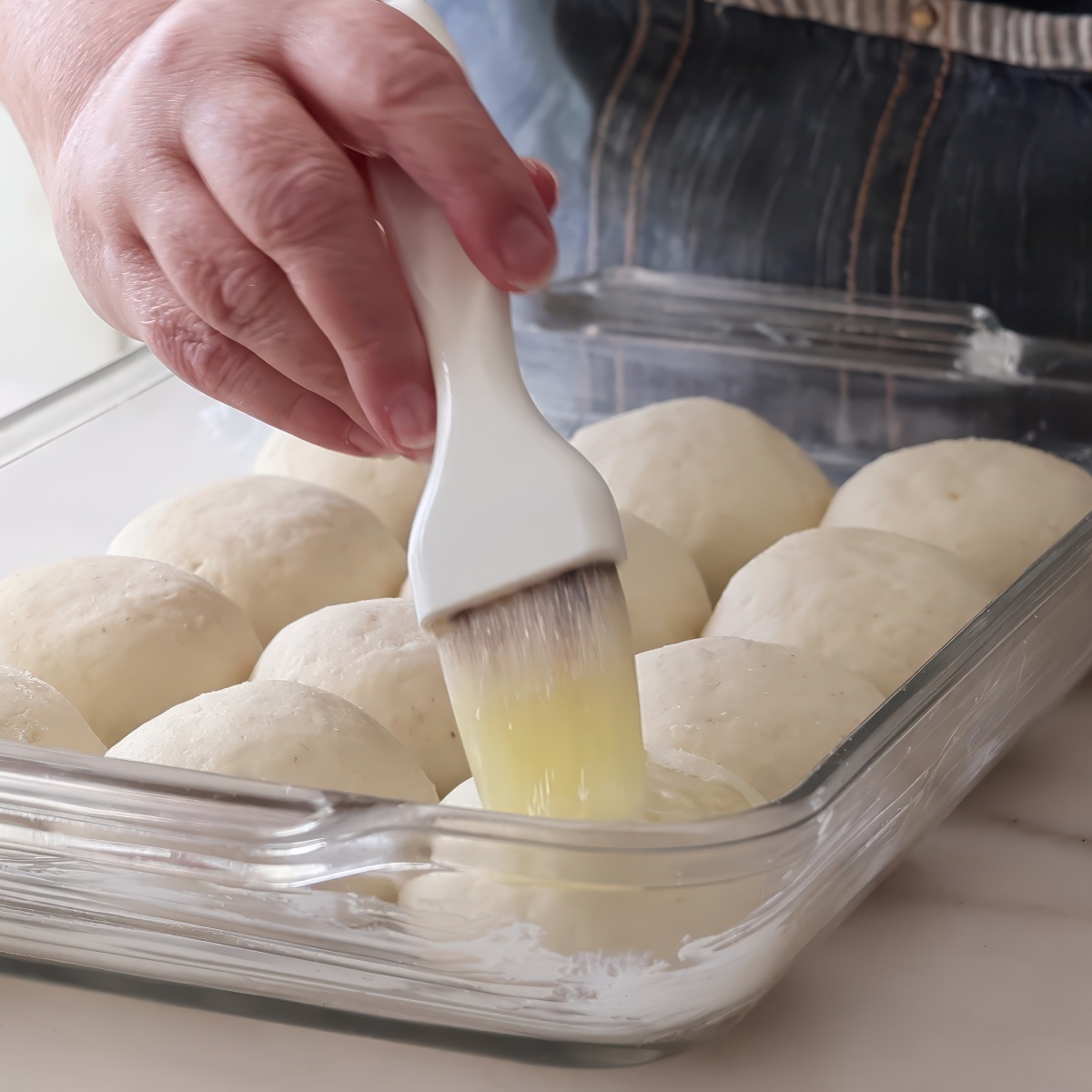 brushing unbaked rolls with butter.