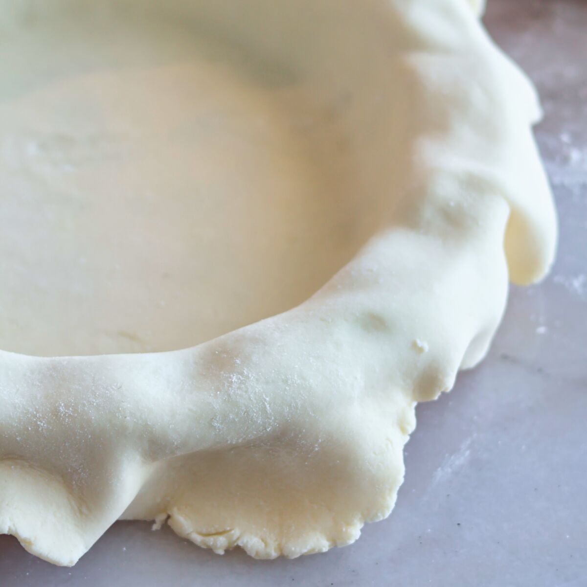 pie crust draped over pie plate.
