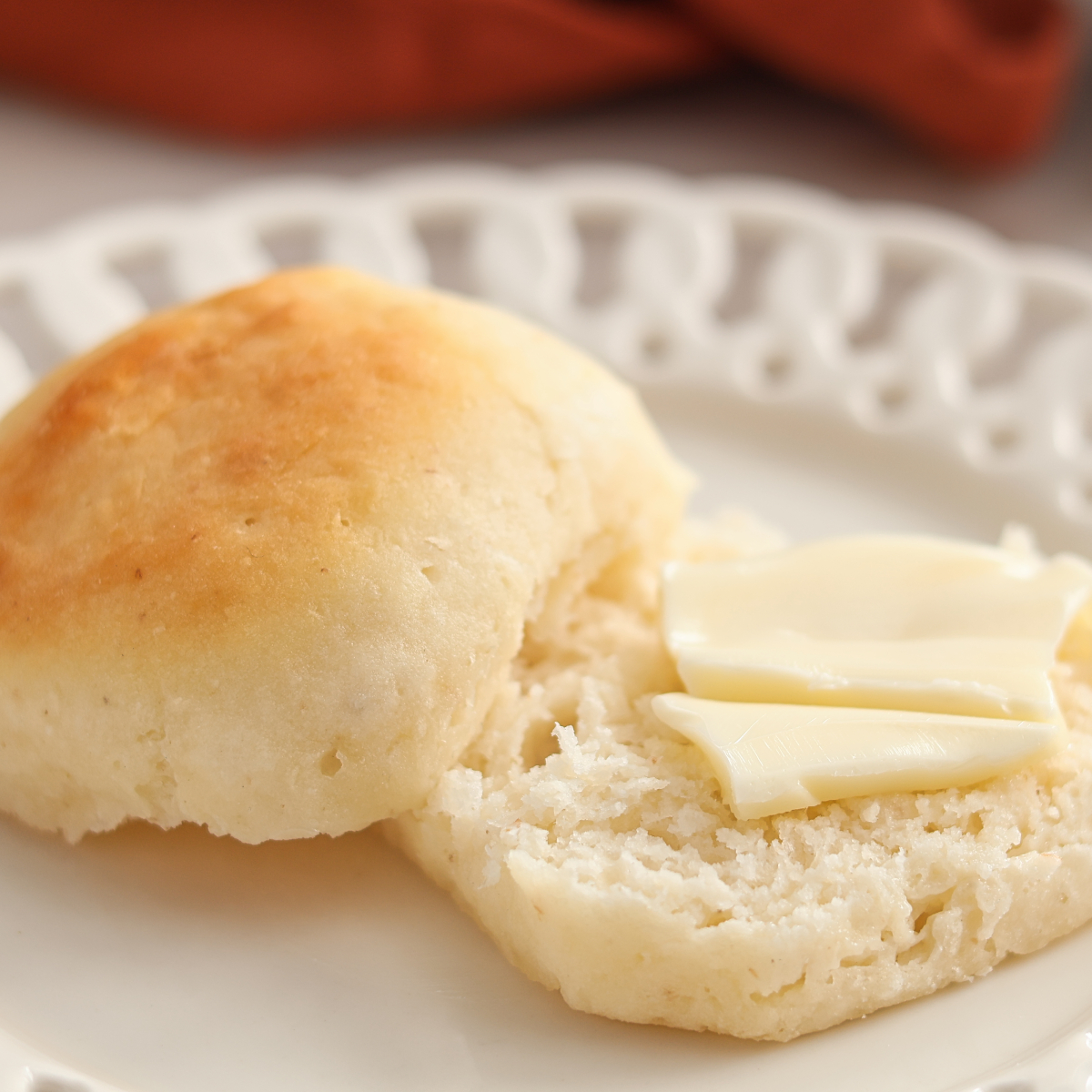 roll split open and bottom half with butter on top.