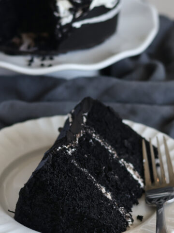 slice of black velvet cake on white plate.