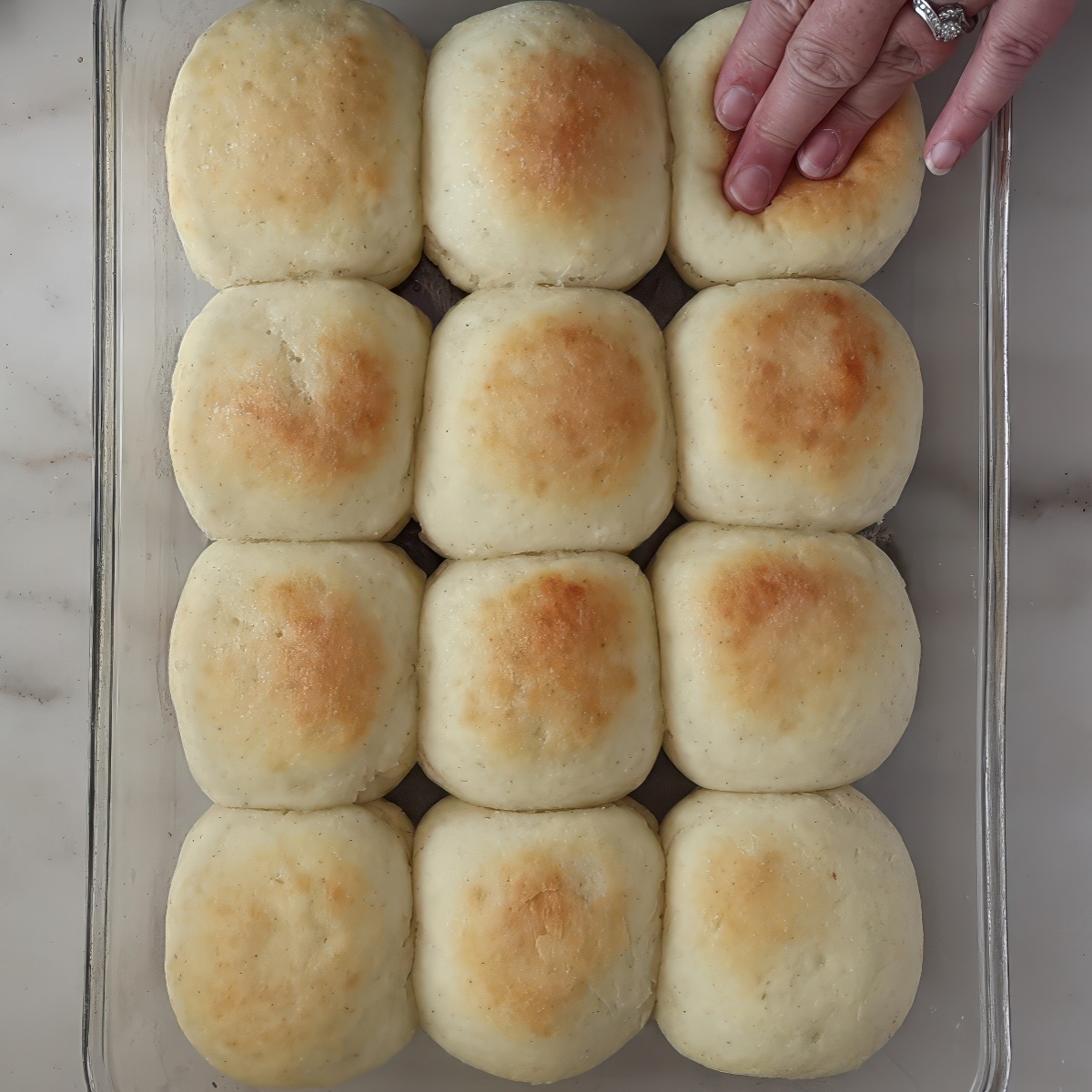 pressing hand down on roll in glass pan.