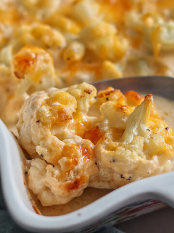 cheesy cauliflower in white baking dish.
