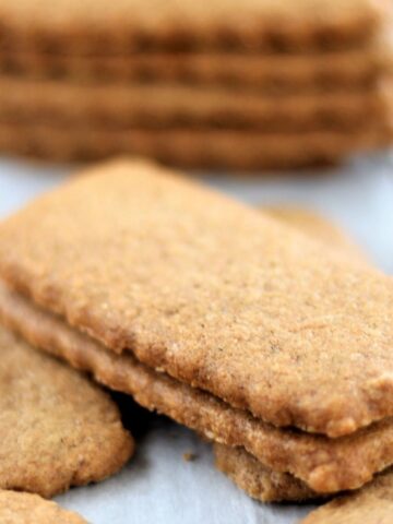 biscoff cookies stacked on parchment paper.